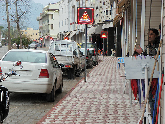 11-02-27-Kemer-49-s.jpg - Die neuen Bürgersteige werden mit rot-weißen Steinen in Rautenform belegt, alle 15 m gibt es einen Fußgängerüberweg mit Absenkung der Bordsteinkante und LED-Warnschild