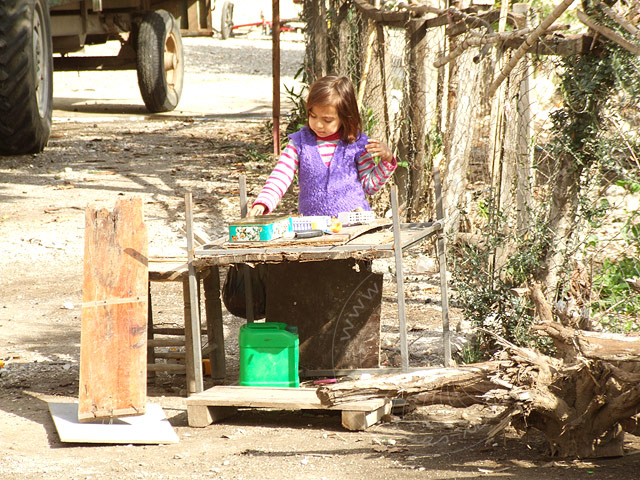9-02-02-Kuzdere-14-s.jpg - Auch abseits vom Markt lohnt sich ein Spaziergang durch Kuzdere. Dieses Mädchen hatte sich im Frühjahr einen eigenen kleinen Marktstand in der Hofeinfahrt aufgebaut - früh übt sich!